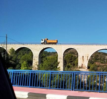 IMATGES CURIOSES: ARA, ELS CAMIONS PER DALT DEL VIADUCTE SOBRE EL RIU (treballs tram del tren, Teulada-Gata-Dénia)